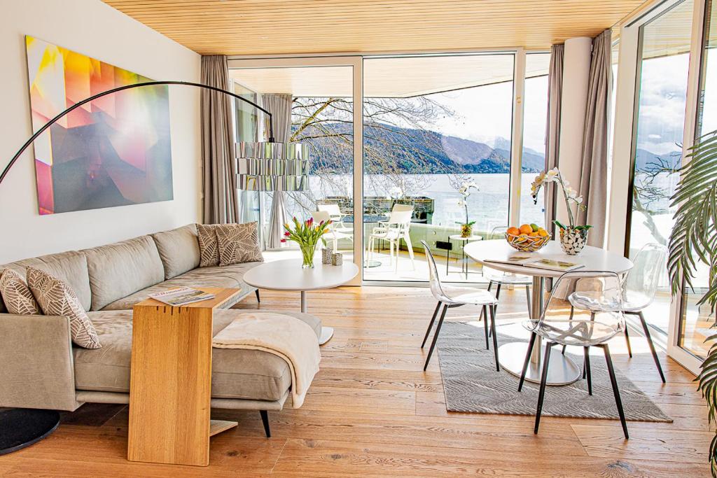 a living room with a couch and a table at Luxus-Apartements direkt am Attersee in Seewalchen