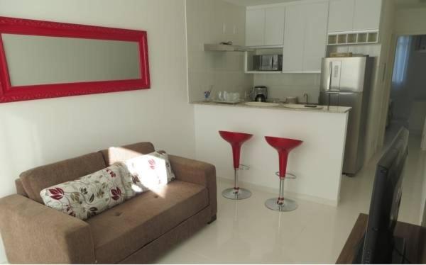 uma sala de estar com um sofá e dois bancos vermelhos em Eco Ribeira em Angra dos Reis
