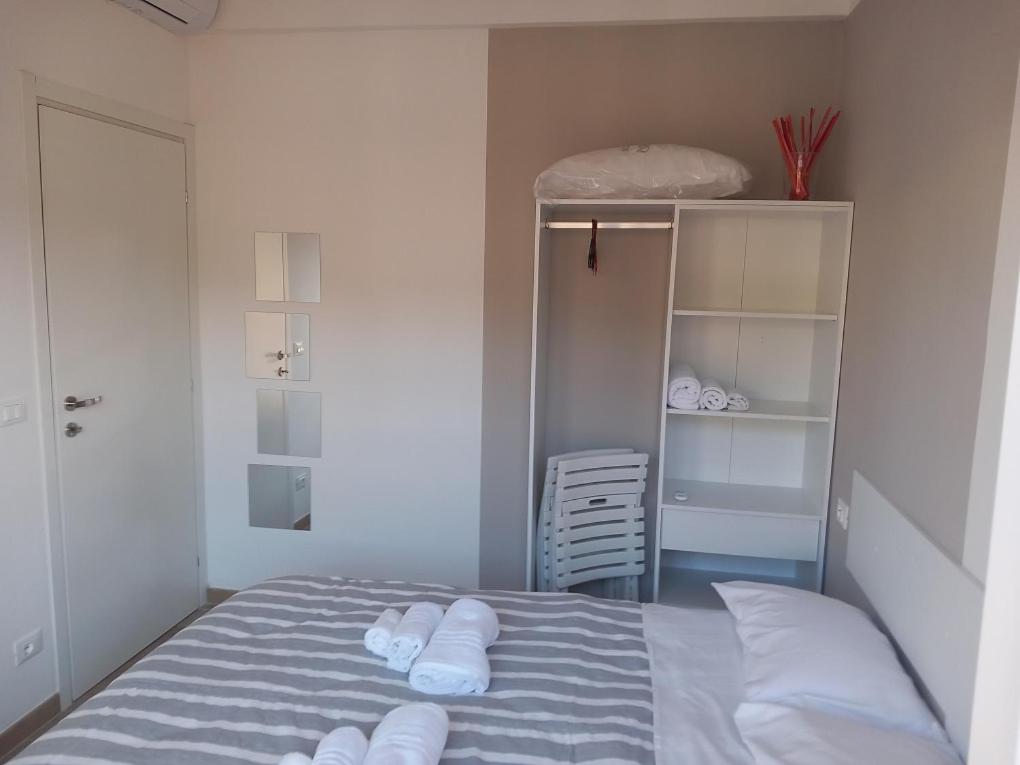 Milly Rooms في سيلي ليجور: غرفة نوم عليها سرير وفوط بيضاء