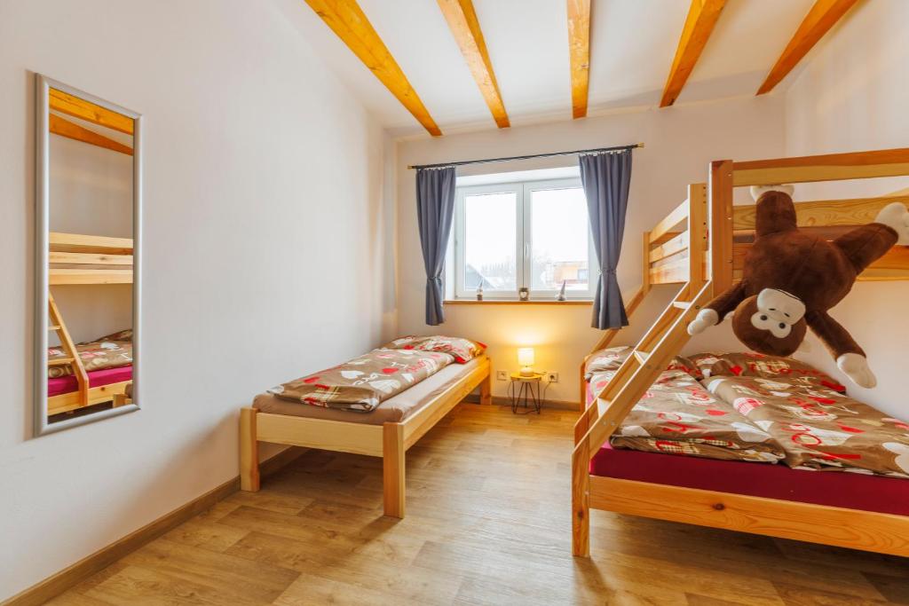 a bedroom with two bunk beds and a teddy bear at Chalupa 66 - Bukovka in Červená Voda
