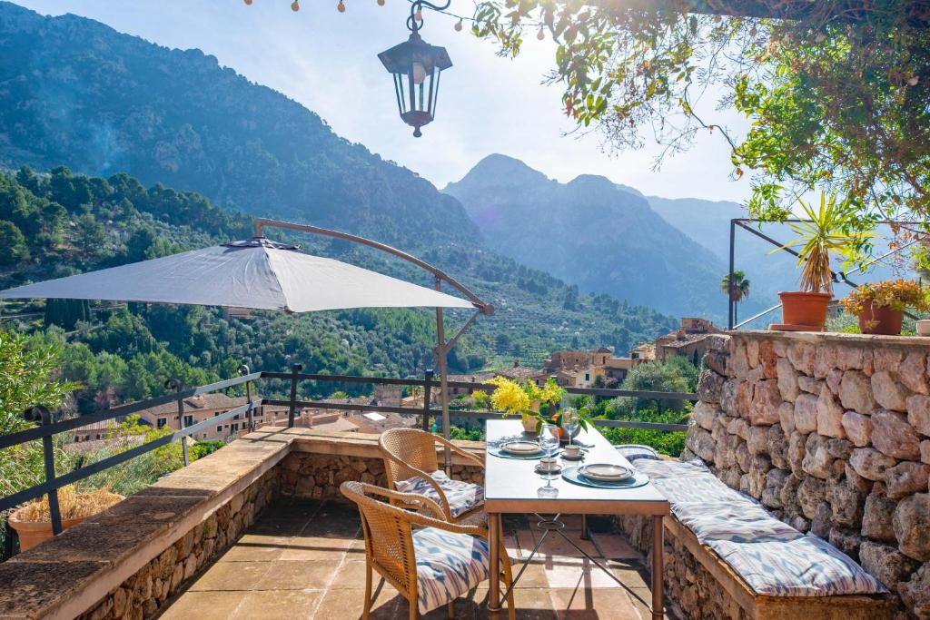 a table and chairs on a patio with a view of mountains at Sa Teulera -Fornalutx- in Fornalutx