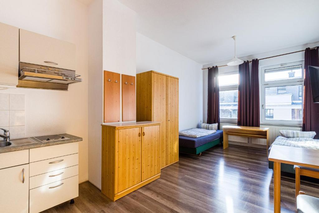 eine Küche mit Holzschränken und ein Wohnzimmer in der Unterkunft Apartmenthaus in Chemnitz für Monteure in Chemnitz