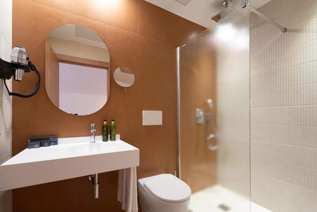a bathroom with a toilet and a sink and a shower at ASA Hotel La Marina in Ondara