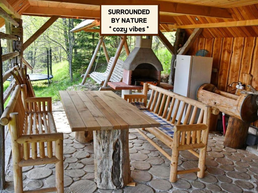 een houten tafel en stoelen met een open haard in een hut bij APARTMA JAKOPIČ in Zgornje Gorje