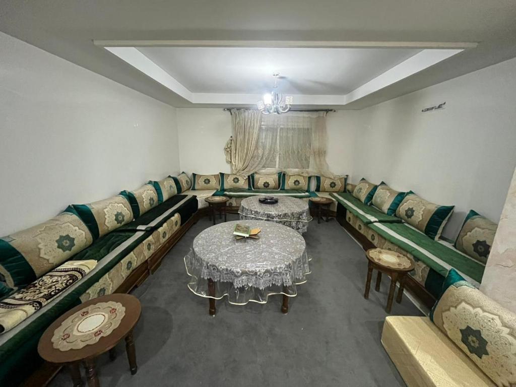 une chambre avec des canapés, une table et des chaises dans l'établissement Annour Luxurious & Large apartment in Oujda Centre, à Oujda