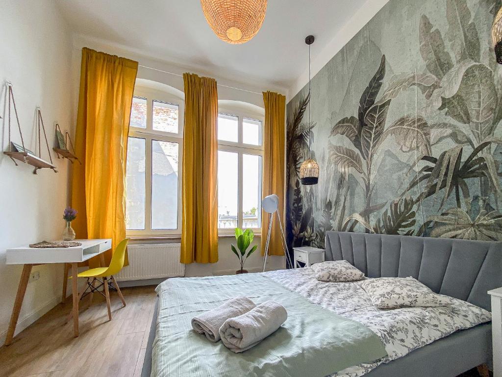 a bedroom with a bed and a large painting on the wall at 34_Boho - DeerRest Apart in Jelenia Góra
