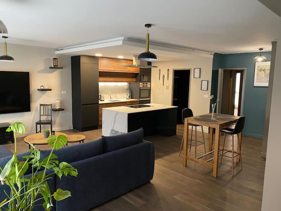 un salon avec un canapé et une cuisine dans l'établissement Appartement Chaleureux à La Madeleine - 2 Chambres, à La Madeleine