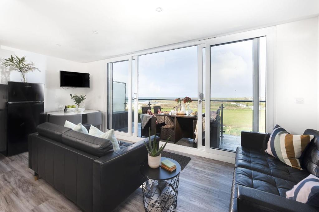 a living room with a couch and a large window at Beachview Apartment 4, Crantock, Newquay in Crantock