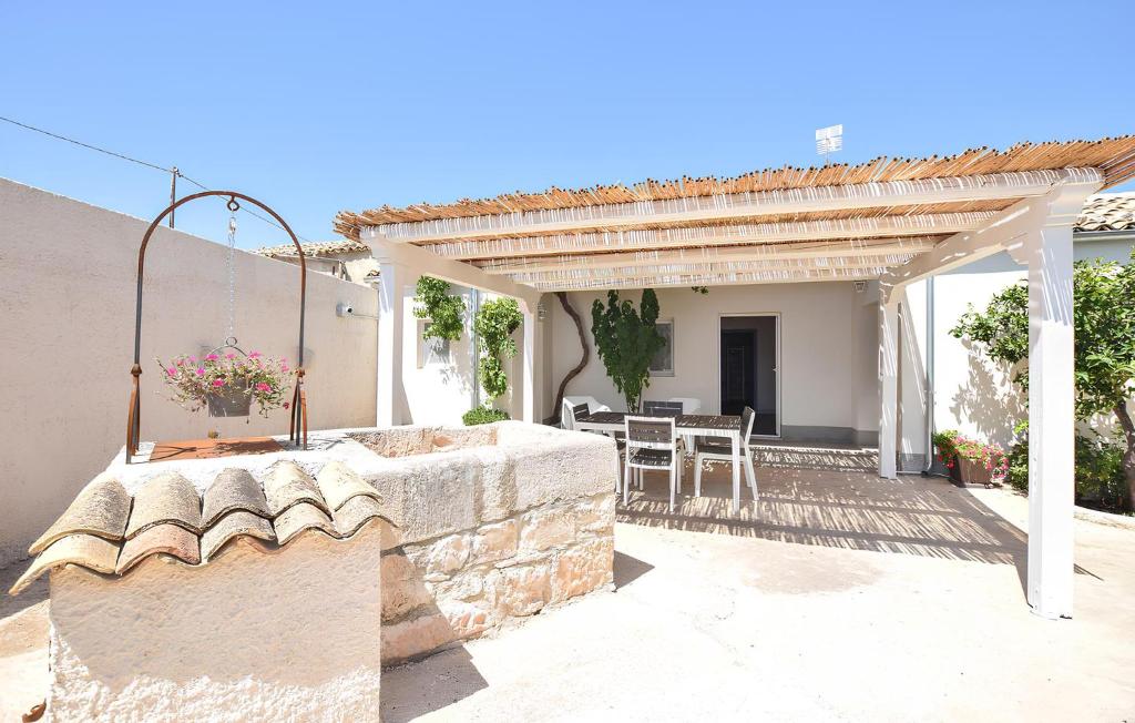 een patio met een stenen muur en een pergola bij Casa DaviRì in Modica