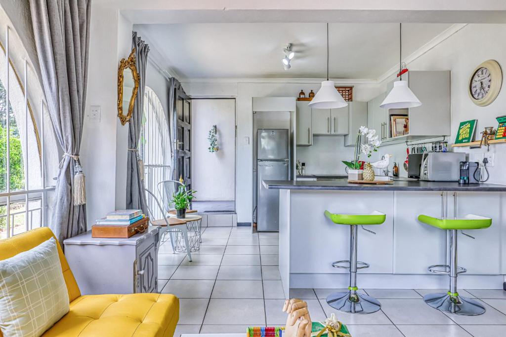 a kitchen and living room with a yellow couch at Chic Midtown Studio-1 Bed-solar-pool-fibre-samrand in Centurion