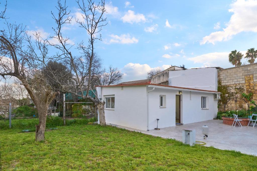 a white house with a yard in front of it at Villa verde Pet-friendly in Córdoba
