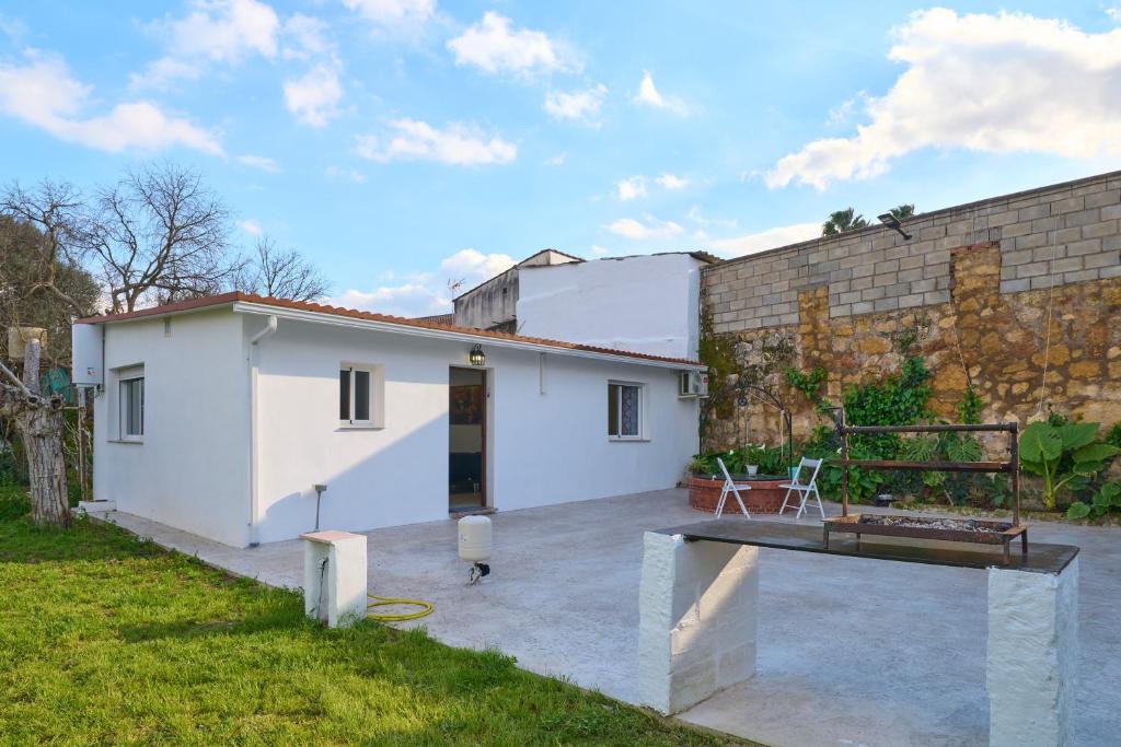 ein weißes Haus mit einer Ziegelwand und einer Terrasse in der Unterkunft Villa verde in Córdoba
