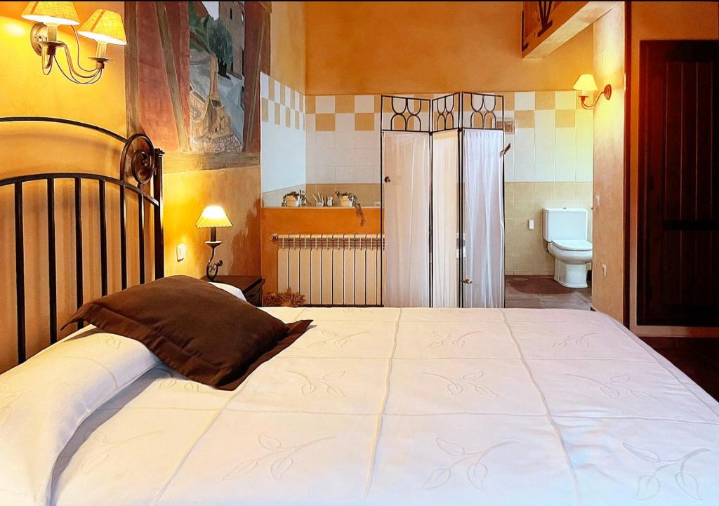 a bedroom with a large bed and a toilet at Alojamientos Rurales EL VALLEJO in Puebla de Vallés