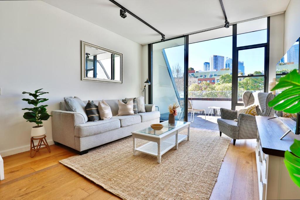 sala de estar con sofá y mesa en Lumière Urban Hideaway-Split Level ·Views ·Parking en Sídney