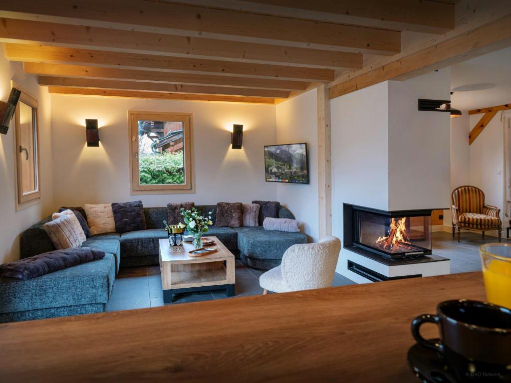 a living room with a couch and a fireplace at Chalet Evonyx - OVO Network in Samoëns