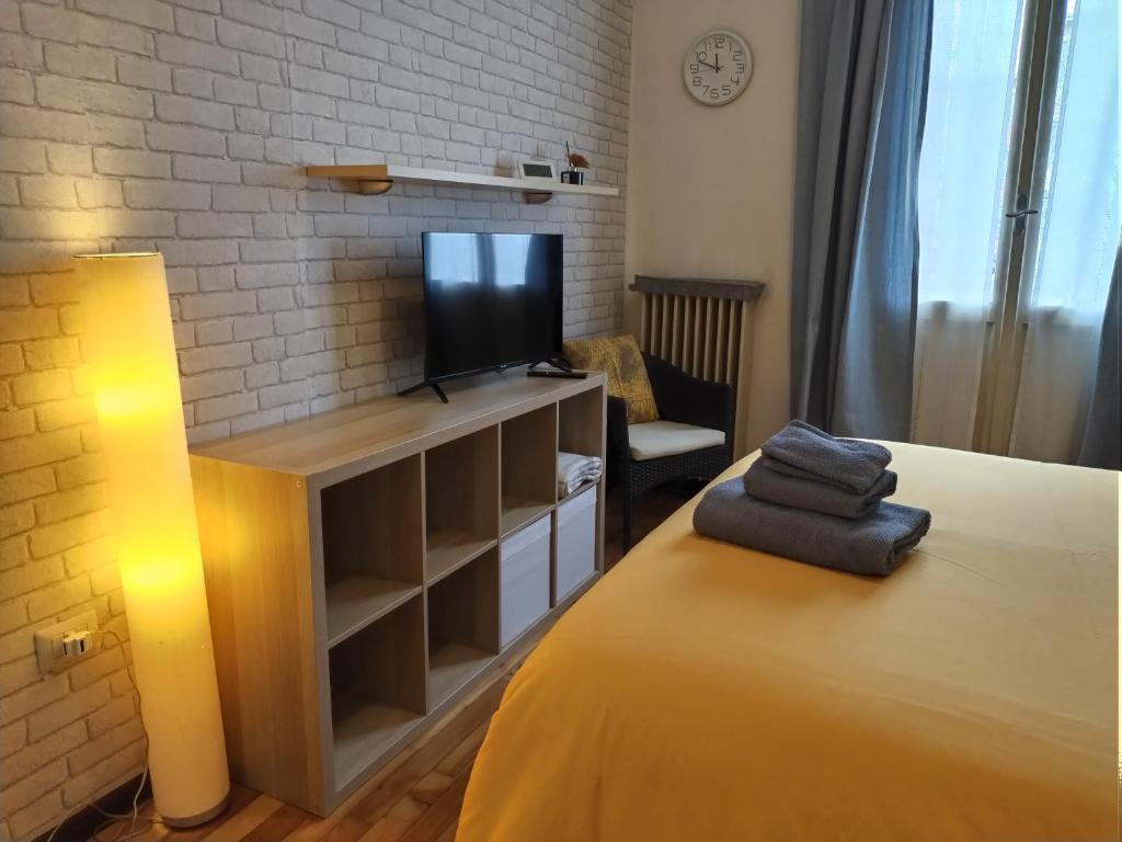 - un salon avec un lit et une télévision dans l'établissement La casetta di Elena - Sondrio Valtellina, à Sondrio