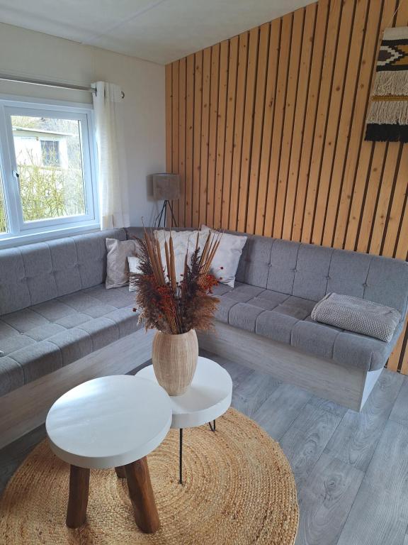 a living room with a couch and a table at EnJoy Meer und See Ferienhaus -Aan het Lauwersmeer in Lauwersoog -3 Slaapkamers - 1 tot 6 pers -Vanaf 14u al inchecken! Free WIFI! in Lauwersoog