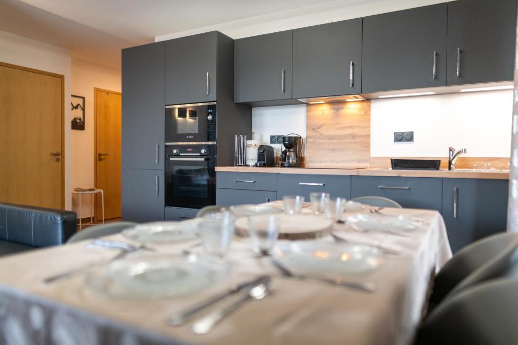 een keuken met een tafel met borden en bestek bij New high-end apartment 6P3BR - Haut Combloux in Cordon