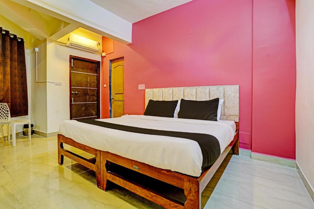 a bedroom with a bed with a pink wall at Collection O Sunset Residency in Mumbai