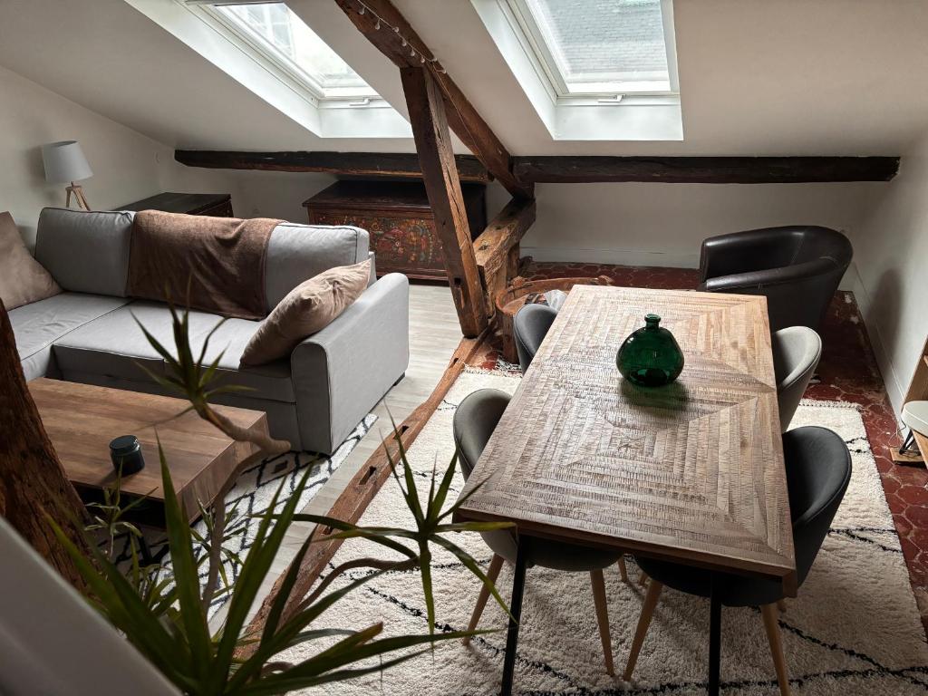 un salon avec une table et un canapé dans l'établissement Appartement atypique à deux pas du Château de Versailles, à Versailles