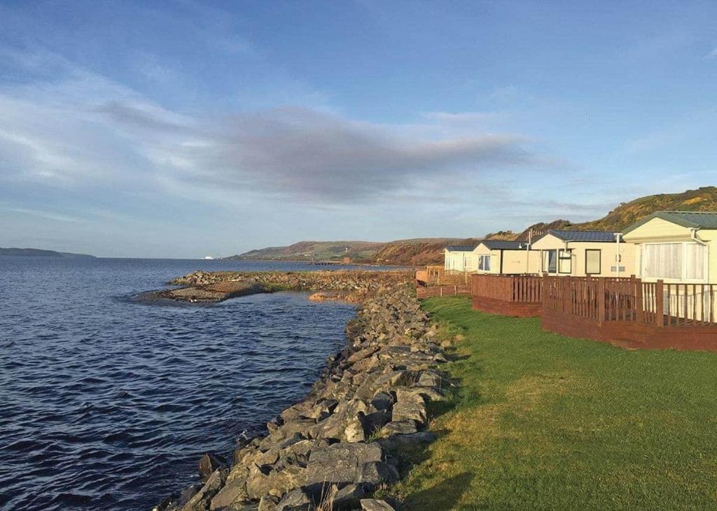 a row of houses on the shore of a body of water at Ryan Bay in Dunragit