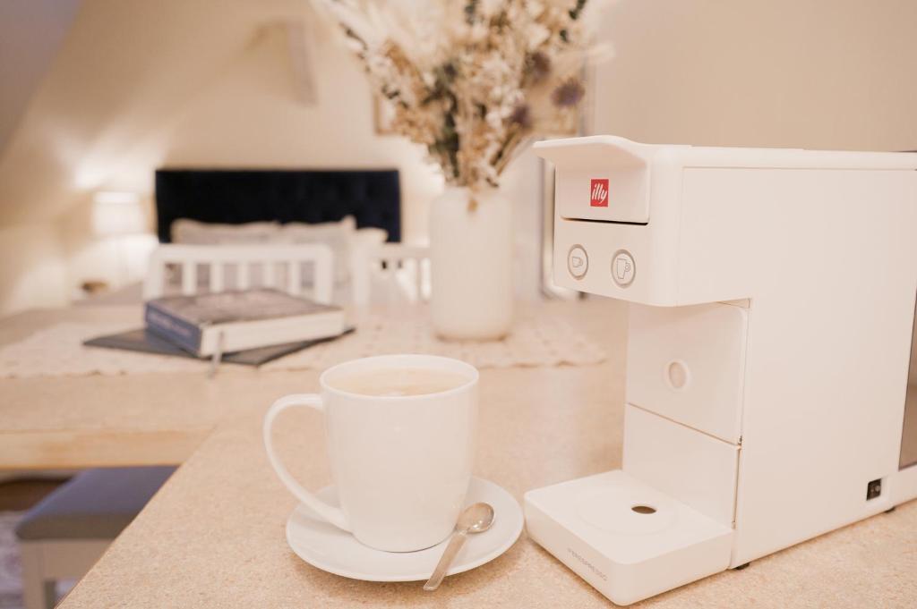 a cup of coffee sitting on a counter next to a sewing machine at Karlamuiza Country Hotel in Kārļi