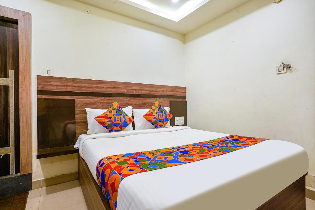 a bedroom with a large bed with a colorful blanket at FabHotel Raj Vihar Residency in Vijayawāda