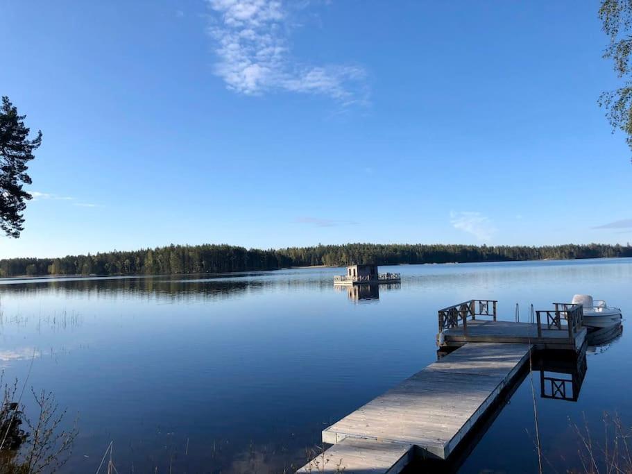 eine Anlegestelle mit einem Boot auf einem großen See in der Unterkunft Luxury Lakeside Villa in Katrineholm
