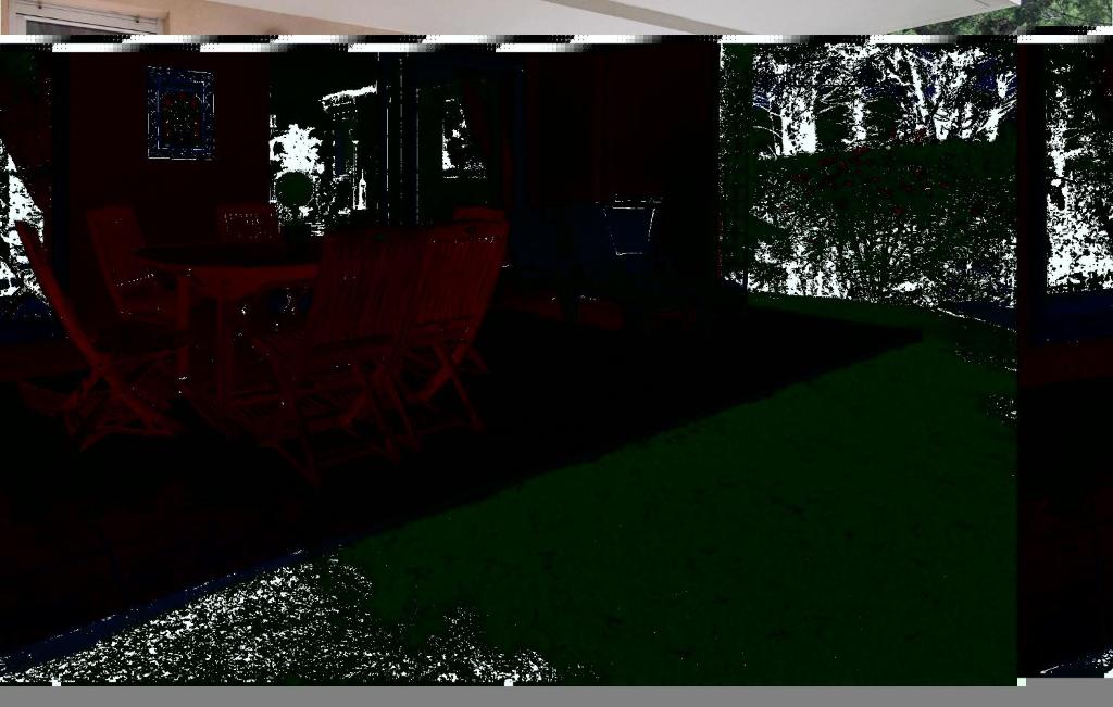 Nice Apartment In Saint Raphael With Outdoor Swimming Pool في سانت رافائيل: غرفة مظلمة مع كراسي وطاولة مع ضوء أخضر