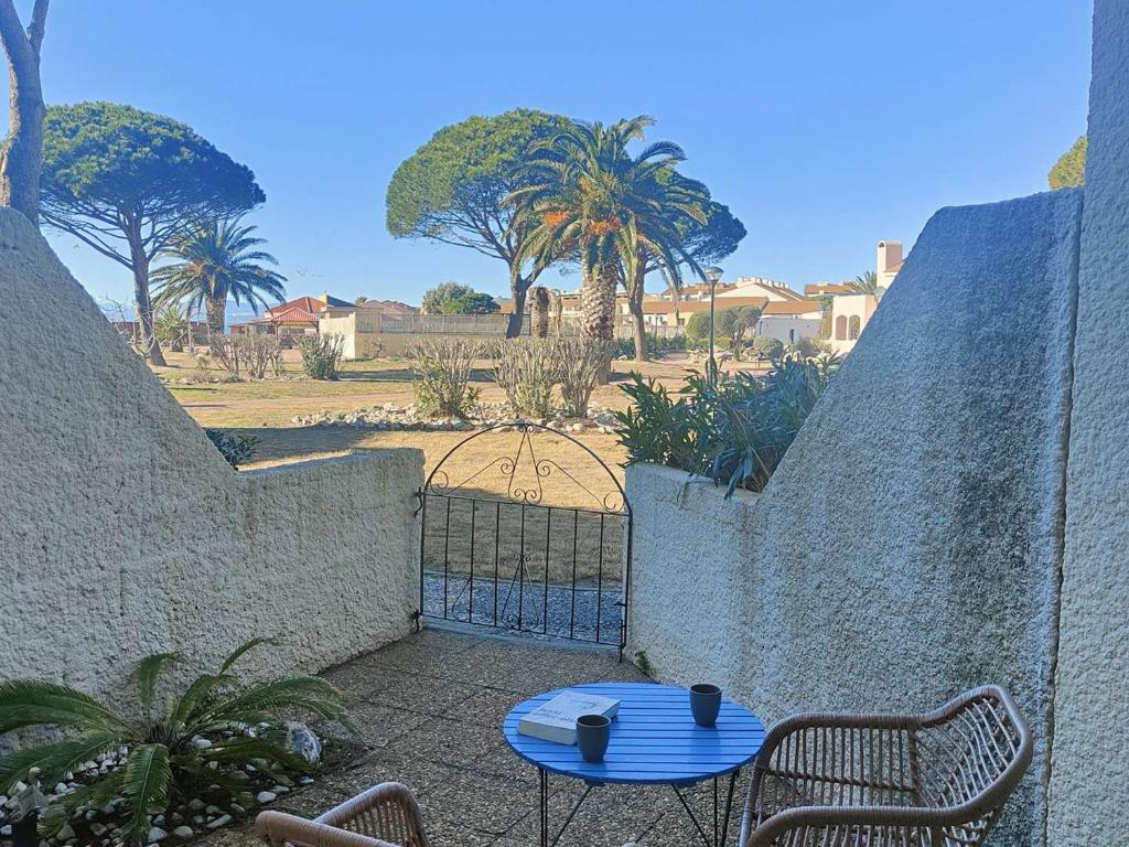 d'une terrasse avec une table bleue et 2 chaises. dans l'établissement Appartement T2 confortable pour 4 pers, RDC, terrasse, parc arboré, piscine, WIFI, parking gratuit - FR-1-195-4, au Barcarès
