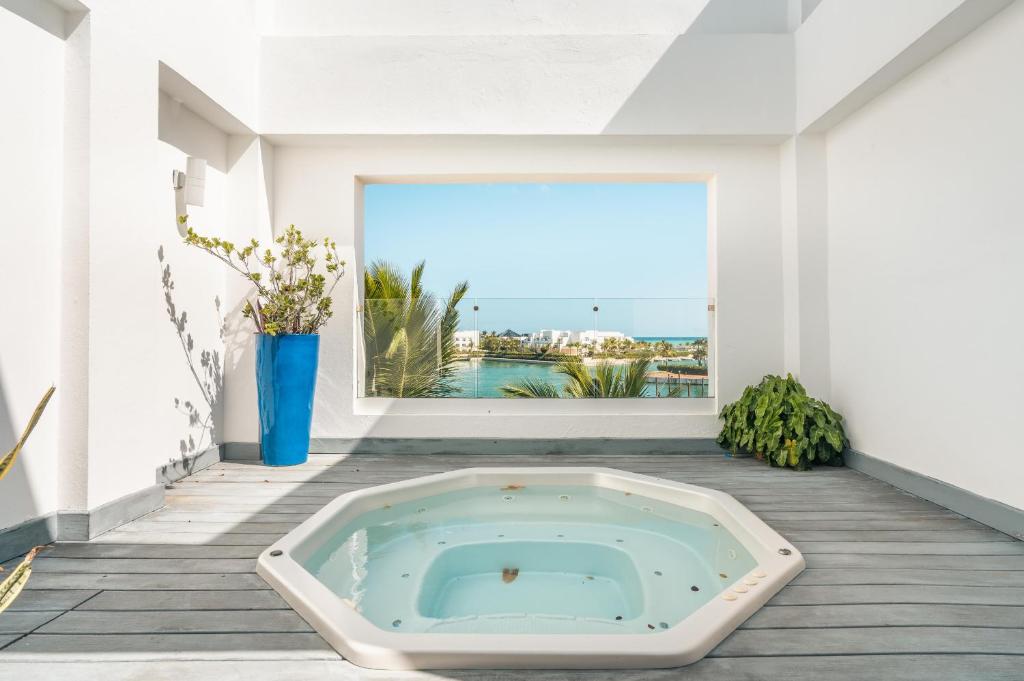 a hot tub in a room with a large window at Magical apartment in Fundadores in Punta Cana