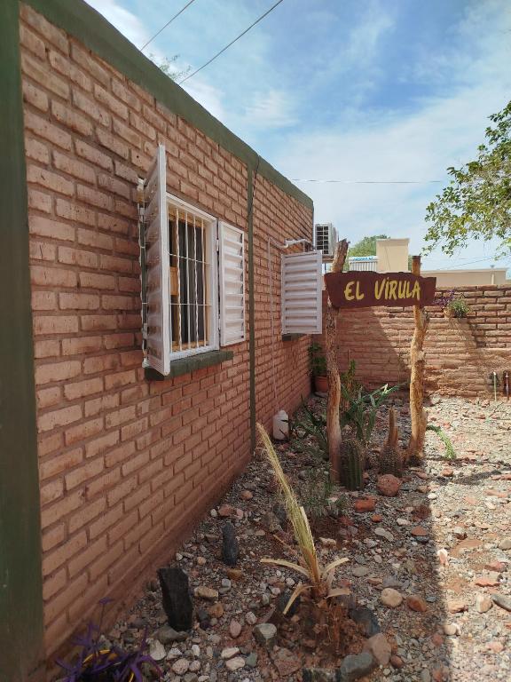 a brick building with a window and a sign at Departamento El Virula in Villa Unión