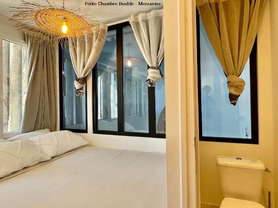 a bedroom with a white bed and a window at LaFrenchCasa Clandestina in Marseille