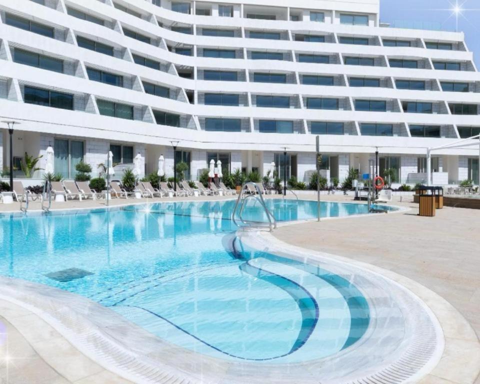 een groot appartementencomplex met een groot zwembad bij Sansa suite SeaSide Sea View dream Apartment in Eilat