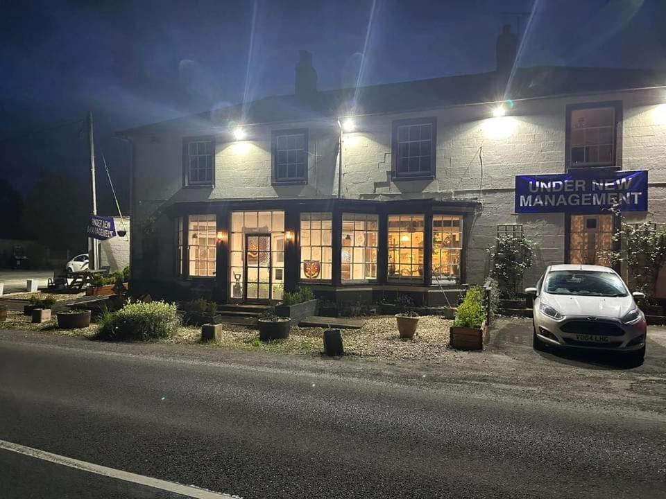 a car parked in front of a building at night at The Penruddocke Arms in Dinton