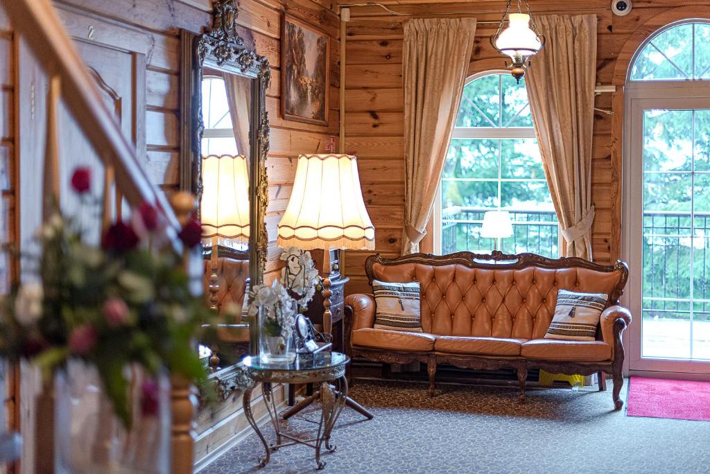 a living room with a couch and two windows at Bražuolėje Pas Juozą- ramiam poilsiui in Trakai