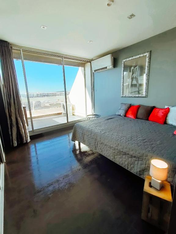 une chambre avec un lit et une grande fenêtre dans l'établissement Village Naturiste Cap d'Agde Le Vip, au Cap d'Agde