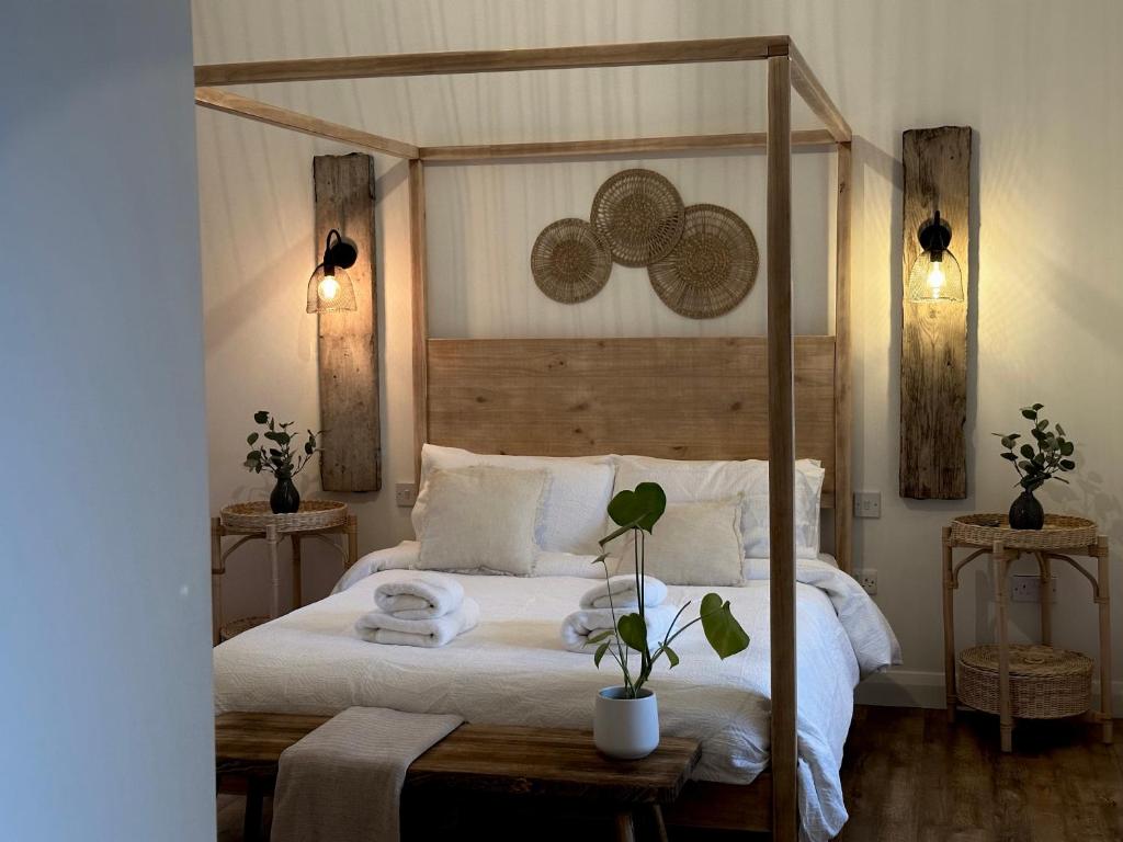 - une chambre avec un grand lit à baldaquin en bois dans l'établissement Croft Cottage by Mourne Homestays, à Glasdrumman