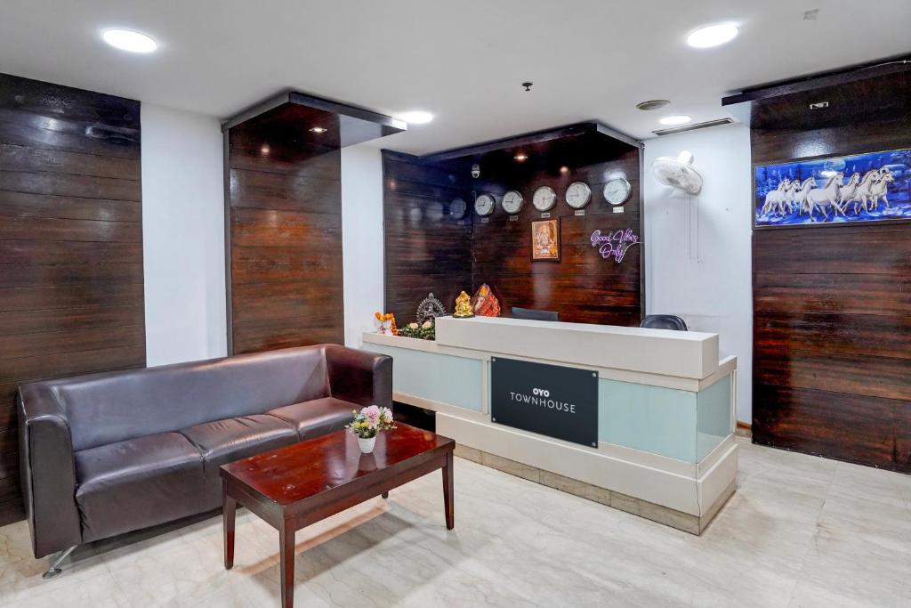 een wachtkamer met een bank en een tafel bij Townhouse 1339 Hotel Anamika Enclave in Gurgaon