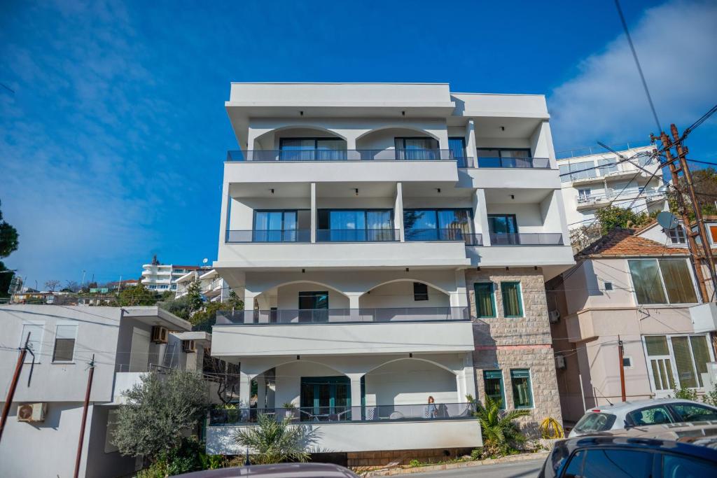 a white building with balconies on a street at Botanica Boutique Hotel in Ulcinj