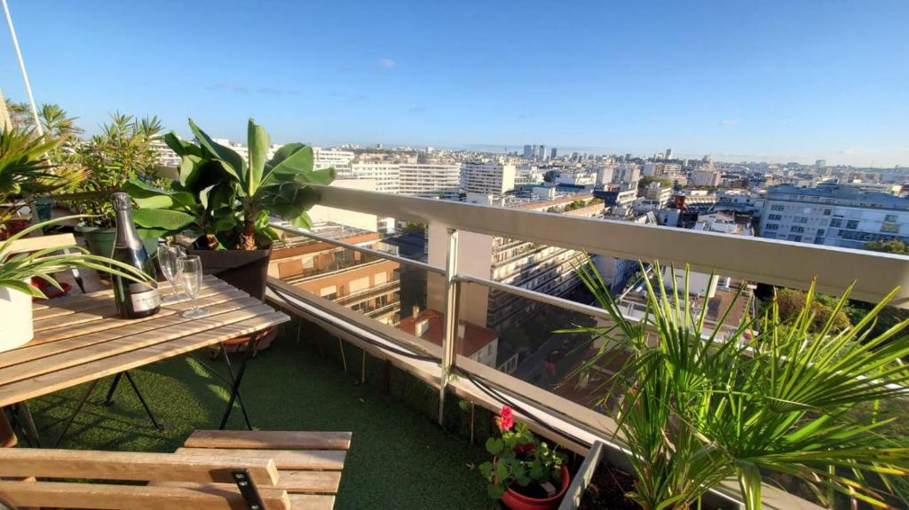 un balcon avec des tables et des plantes en pot et une ville dans l'établissement Dernier étage, 108m2, Vue panoramique, à Paris
