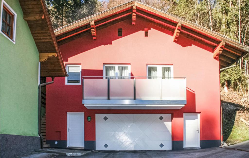 ein rotes Haus mit einem Balkon an der Seite in der Unterkunft Beautiful Apartment In Mhlbach Am Hochknig With Kitchen in Mühlbach am Hochkönig
