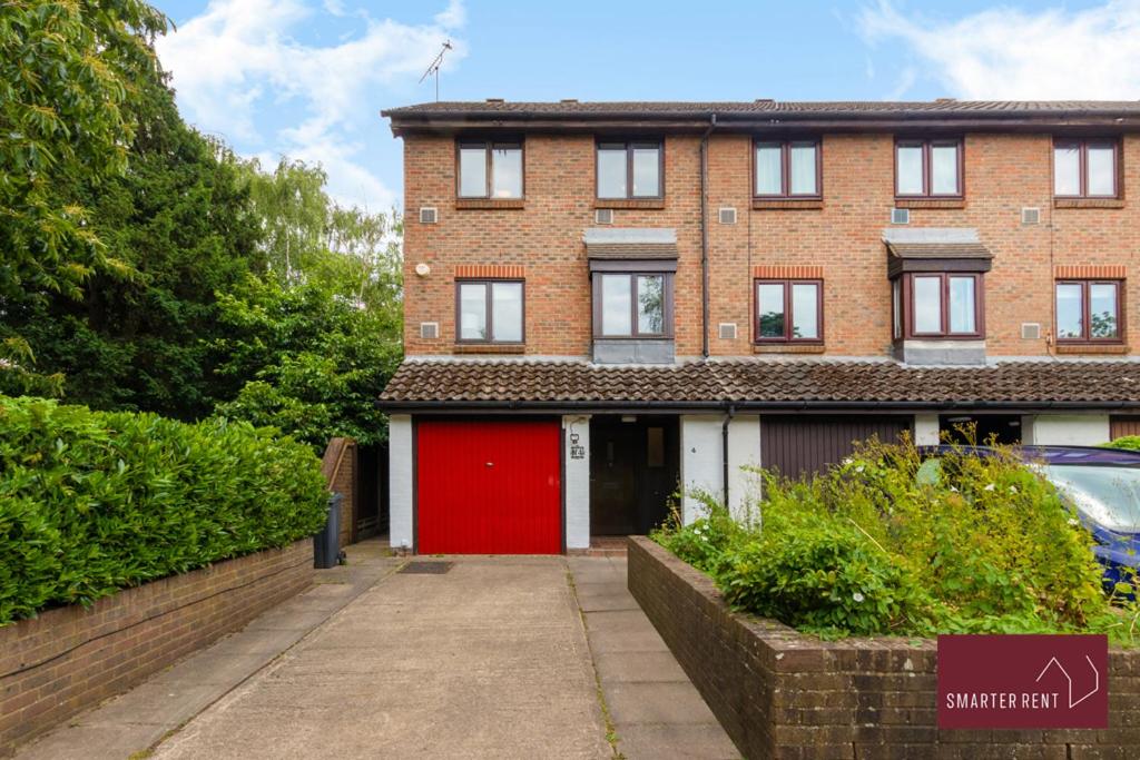 un bâtiment en briques rouges avec un garage rouge dans l'établissement Isleworth - 4 Bed Modern House, à Brentford