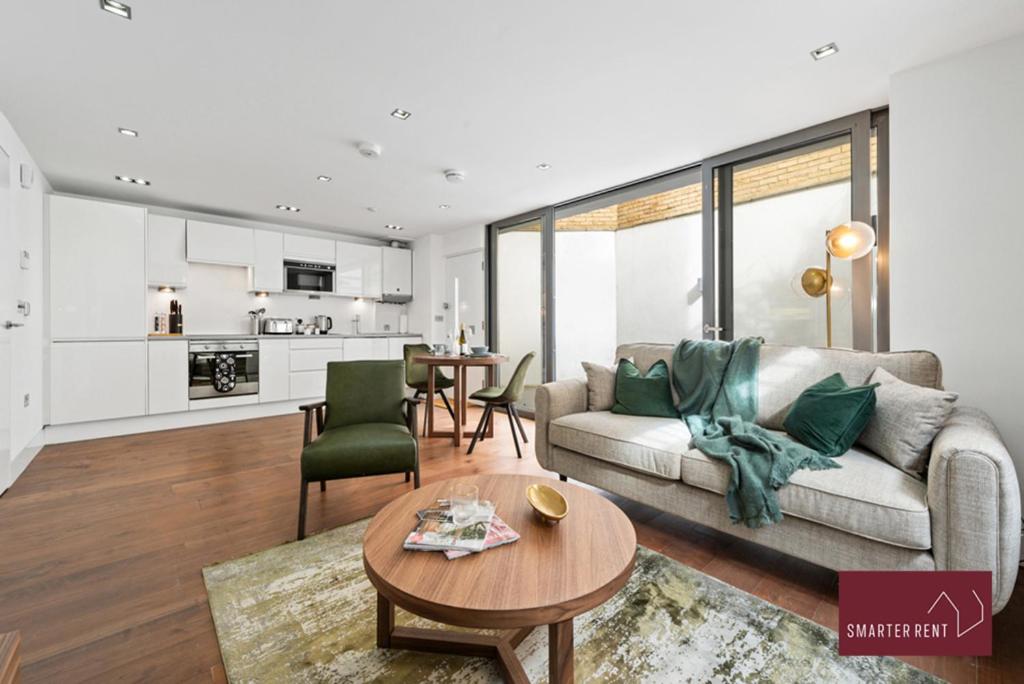 ein Wohnzimmer mit einem Sofa und einem Tisch in der Unterkunft Richmond - 1 Bedroom Apartment - With Garden in Kew