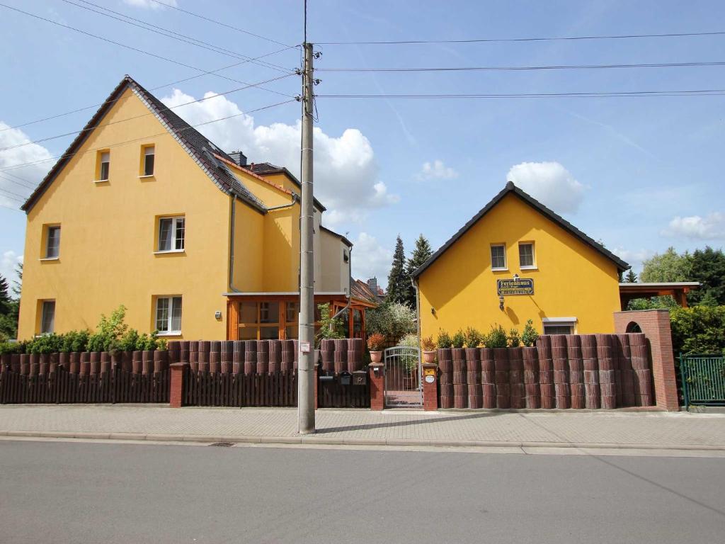 una casa amarilla al lado de una calle en Ferienhaus Familie Berger, en Dessau