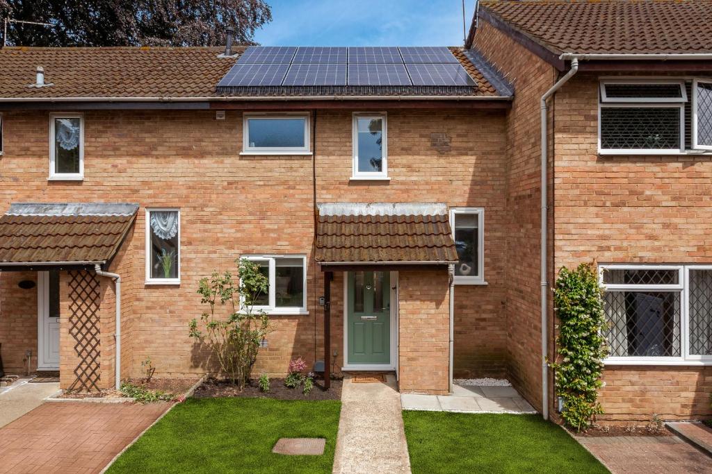 a brick house with a solar roof at Woking - 2 Bed Eco-Friendly Home in Horsell