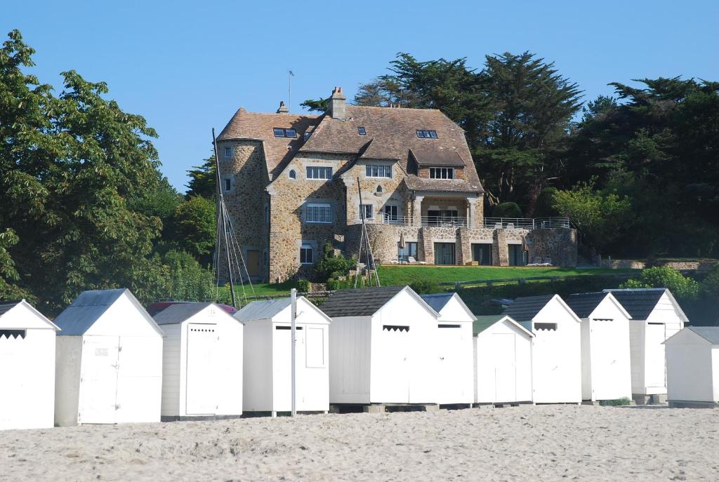 a row of white beach huts in front of a house at Manoir Dalmore in Névez