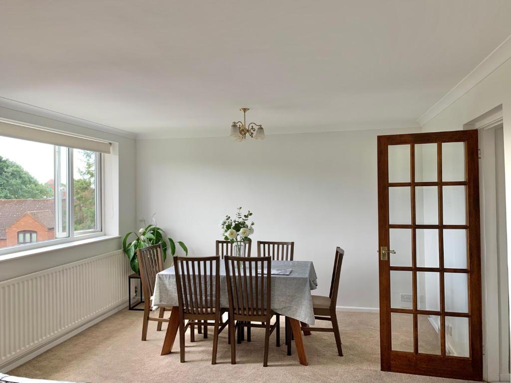 a dining room with a table and chairs and a window at Stratford upon Avon: 2 bed town centre apartment, parking for one car in Stratford-upon-Avon