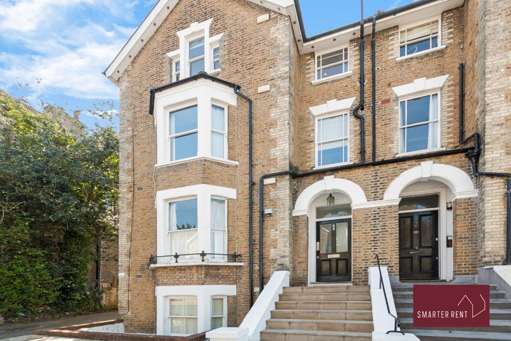 a brick building with stairs in front of it at Richmond - 2 Bedroom Duplex Apartment in Richmond upon Thames