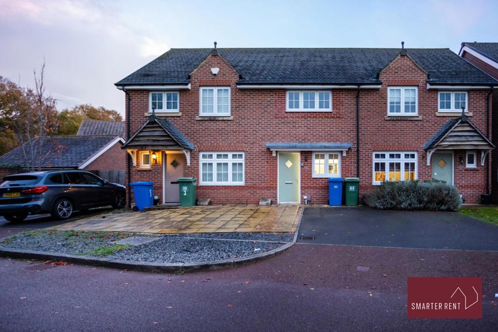 a brick house with a car parked in a driveway at Jennett's Park, Bracknell - 2 Bedroom Home - Garden & Parking in Bracknell